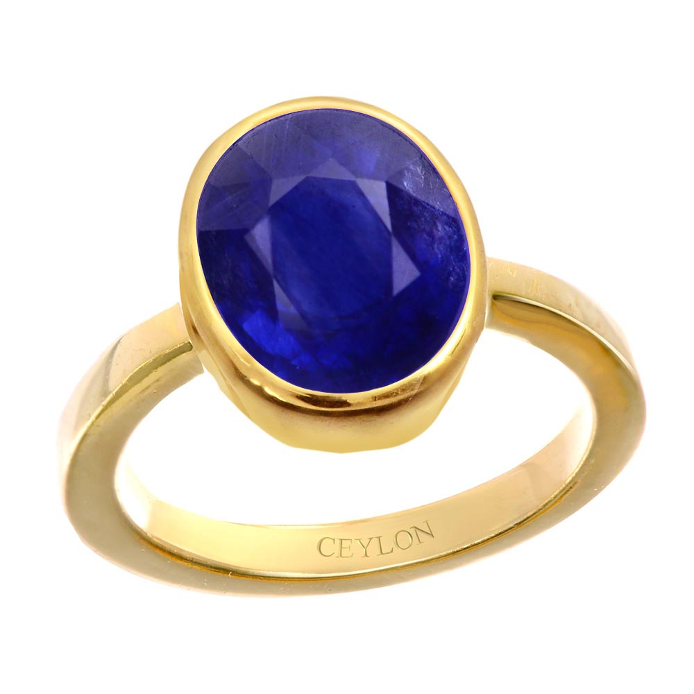 Premium Photo | A gold ring with blue stone and diamonds on a blue  background.